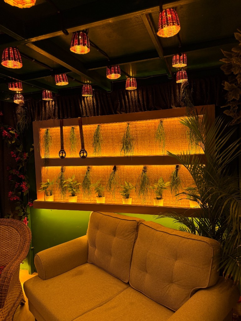 Beige sofa facing the biophilic plant wall inside the studio